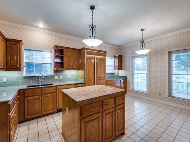 kitchen featuring a sink, wood counters, crown molding, and wallpapered walls