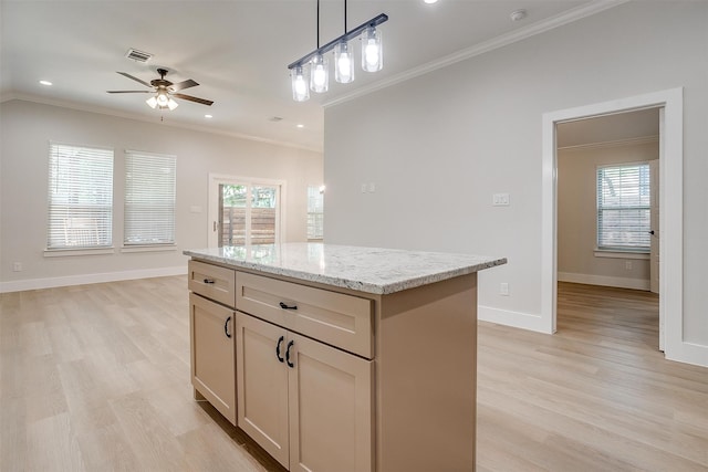 kitchen with light hardwood / wood-style floors, a kitchen island, light stone countertops, ceiling fan, and ornamental molding