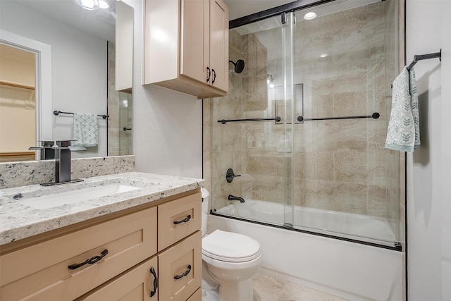 full bathroom featuring enclosed tub / shower combo, vanity, and toilet