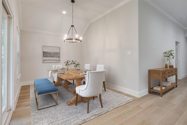 dining room with an inviting chandelier, lofted ceiling, ornamental molding, and light hardwood / wood-style floors