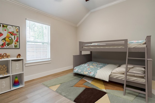 bedroom with light wood-type flooring, lofted ceiling, and ornamental molding