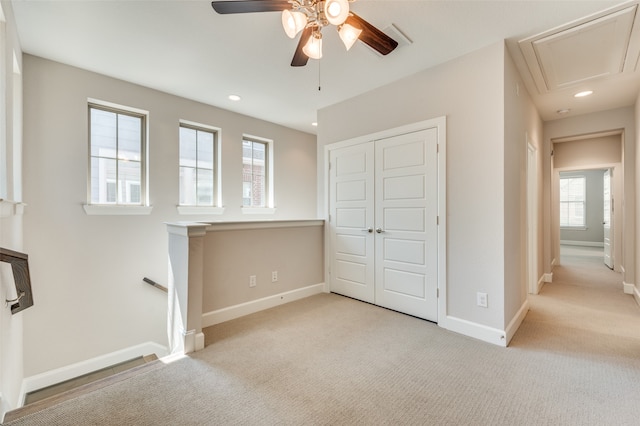 unfurnished bedroom with a closet, ceiling fan, and light carpet