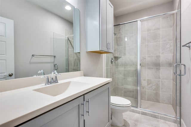 bathroom with tile patterned flooring, an enclosed shower, toilet, and vanity