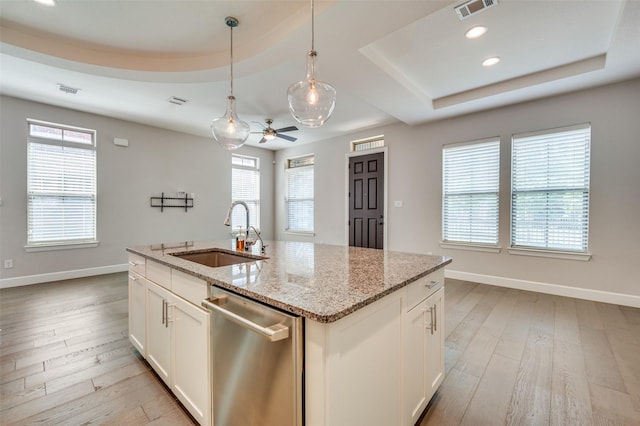 kitchen with stainless steel dishwasher, sink, a raised ceiling, light wood-type flooring, and ceiling fan