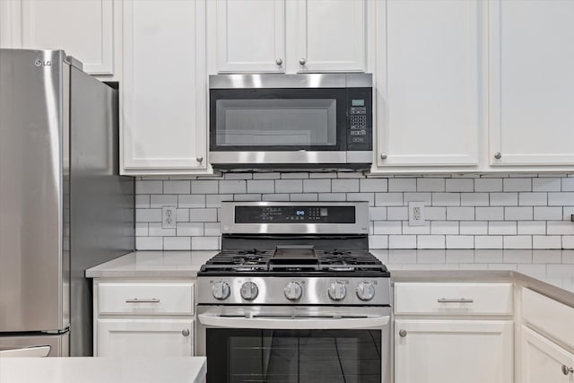 kitchen featuring white cabinets, decorative backsplash, and appliances with stainless steel finishes