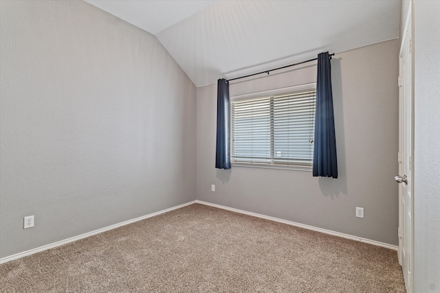 carpeted empty room featuring lofted ceiling