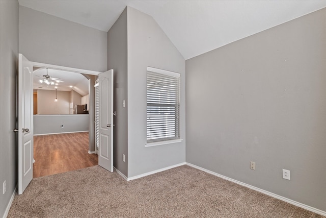 carpeted empty room with vaulted ceiling and ceiling fan