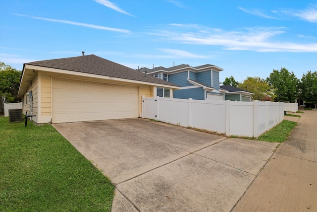 view of side of property with central air condition unit, a garage, and a lawn