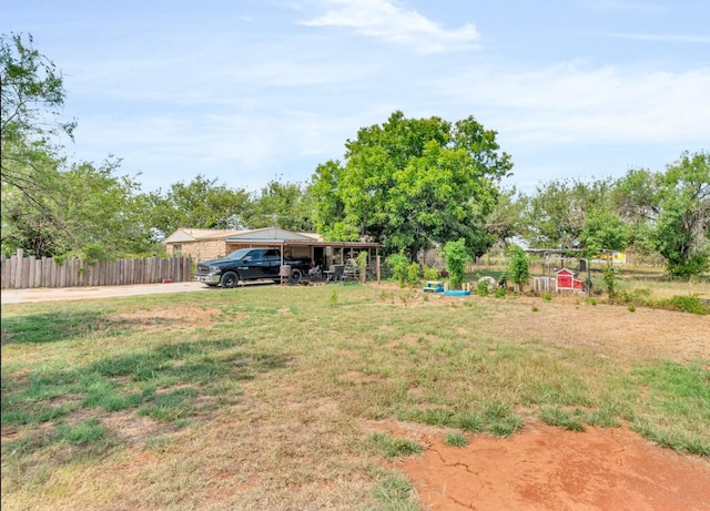 view of yard featuring a carport and fence