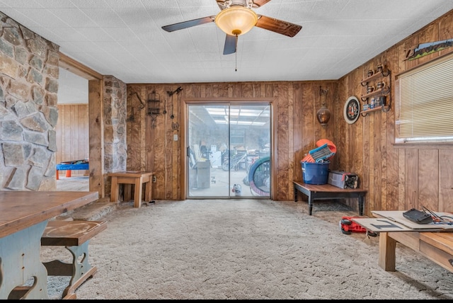 misc room featuring ceiling fan, carpet, and wood walls