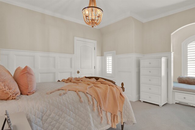 bedroom featuring ornamental molding, an inviting chandelier, and light colored carpet