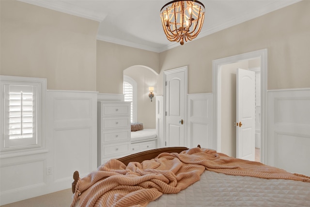 carpeted bedroom with ornamental molding and a notable chandelier