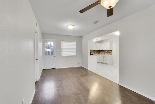 unfurnished living room with wood-type flooring and ceiling fan