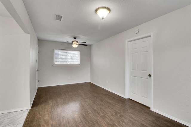 unfurnished room with ceiling fan and dark wood-type flooring