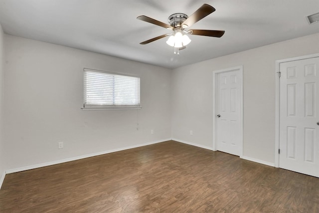 unfurnished bedroom featuring ceiling fan, dark hardwood / wood-style floors, and multiple closets