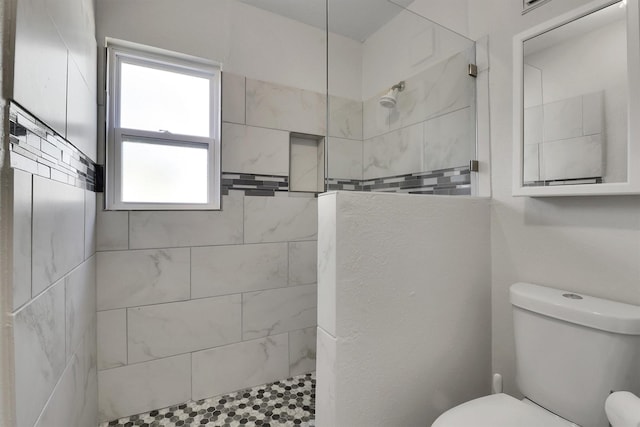 bathroom with tiled shower and toilet