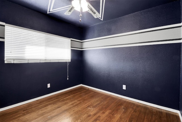 empty room with ceiling fan and wood-type flooring