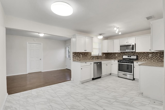 kitchen featuring backsplash, stainless steel appliances, white cabinetry, and sink