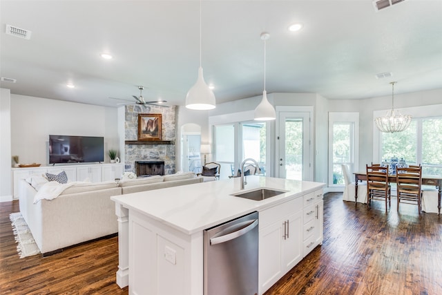 kitchen featuring a fireplace, sink, dark hardwood / wood-style flooring, and stainless steel dishwasher