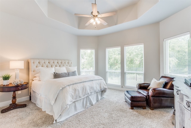 bedroom featuring multiple windows, carpet, ceiling fan, and a raised ceiling