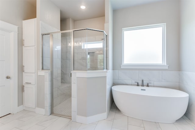 bathroom with plus walk in shower, tile walls, and tile patterned floors