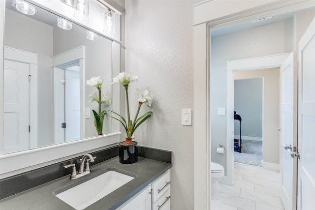 bathroom featuring vanity, toilet, and tile patterned flooring