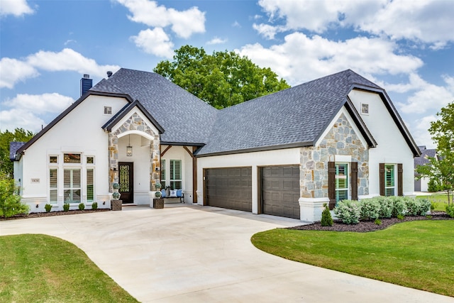 french country inspired facade featuring a garage and a front yard