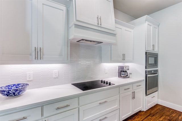 kitchen with appliances with stainless steel finishes, decorative backsplash, white cabinetry, dark wood-type flooring, and custom range hood