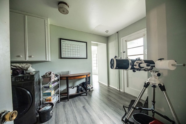 exercise area with light hardwood / wood-style floors and washer / dryer