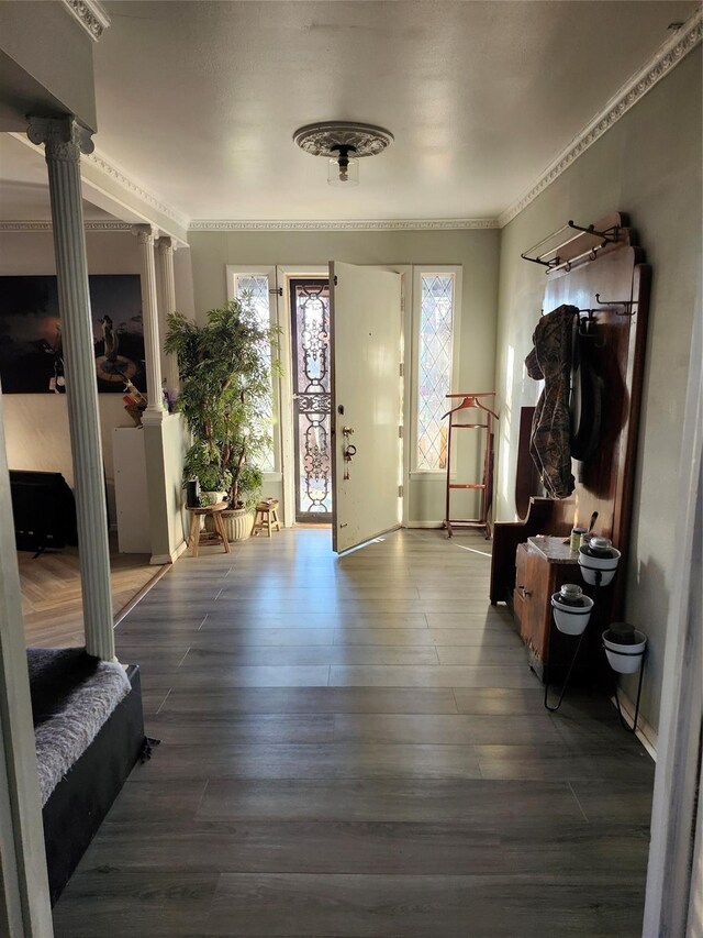 foyer with decorative columns, hardwood / wood-style flooring, plenty of natural light, and crown molding