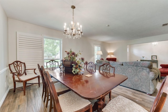 dining space featuring a notable chandelier and light hardwood / wood-style floors