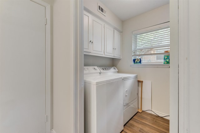 washroom with washer and clothes dryer and cabinets