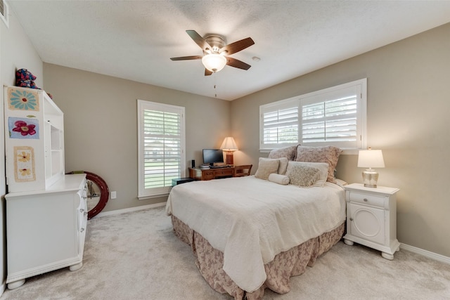 carpeted bedroom with multiple windows and ceiling fan