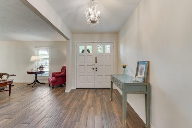 entryway featuring wood-type flooring and a chandelier