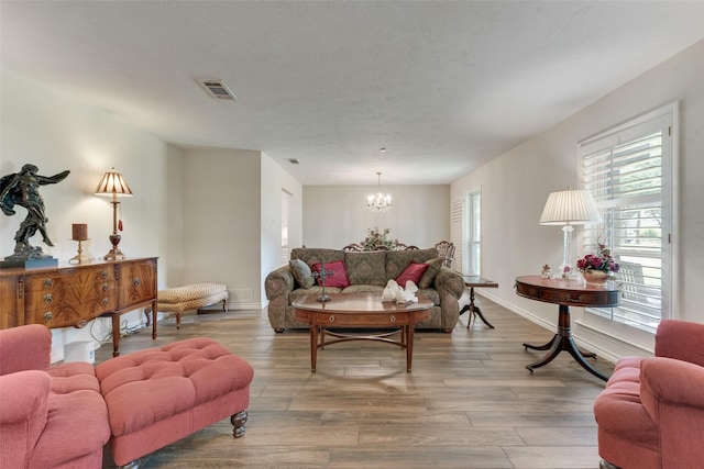 living room with wood-type flooring and a notable chandelier