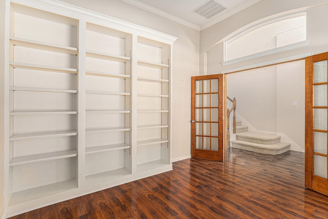 spare room featuring built in shelves, ornamental molding, dark wood-type flooring, and french doors