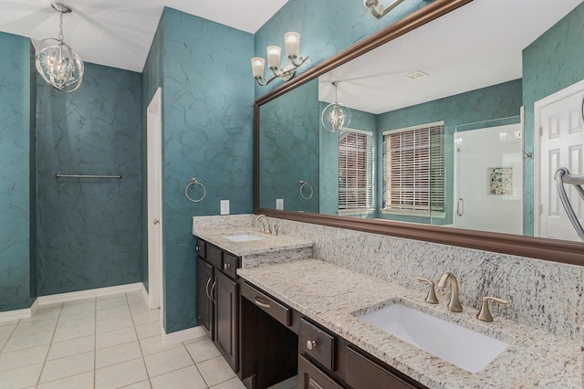 bathroom featuring a sink, an inviting chandelier, tile patterned floors, and double vanity