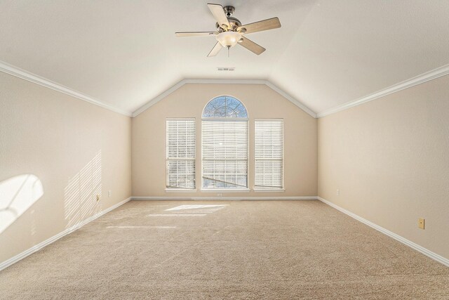 empty room featuring carpet, a ceiling fan, visible vents, lofted ceiling, and ornamental molding