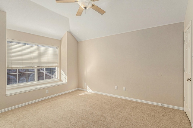 spare room featuring baseboards, a ceiling fan, carpet flooring, and vaulted ceiling