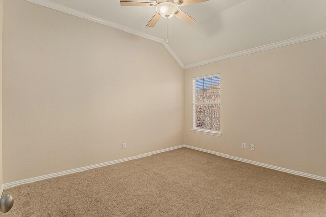 carpeted spare room with vaulted ceiling, baseboards, a ceiling fan, and ornamental molding