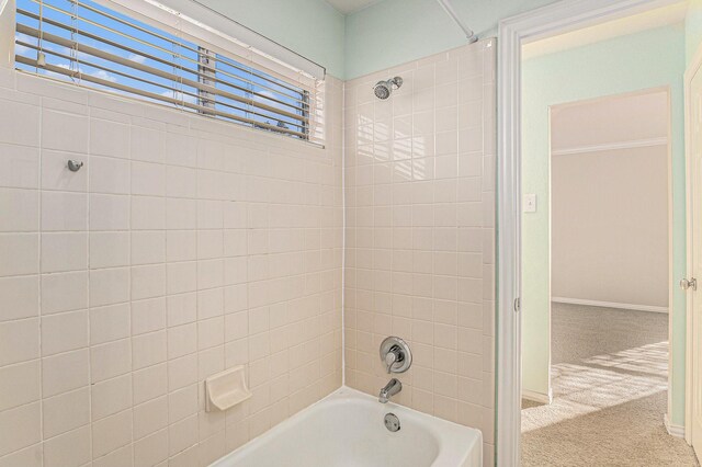 bathroom with shower / bathing tub combination and baseboards