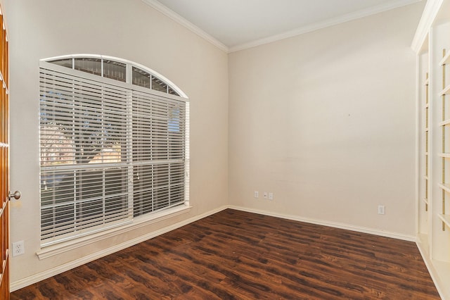 empty room featuring crown molding, wood finished floors, and baseboards