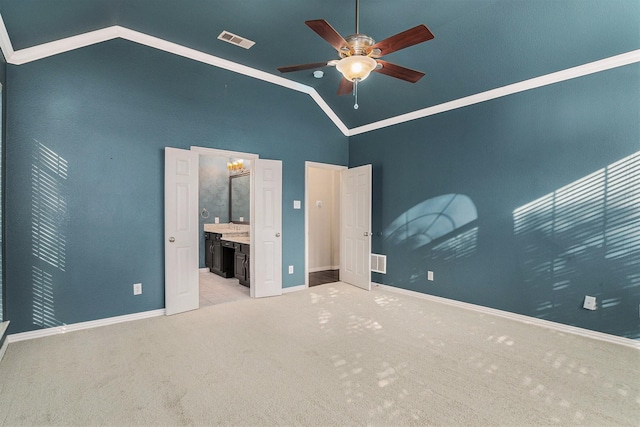 unfurnished bedroom featuring ensuite bath, high vaulted ceiling, ceiling fan, light colored carpet, and crown molding