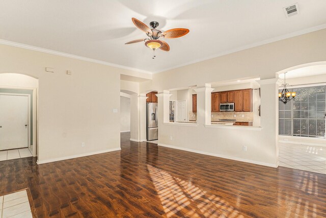 unfurnished living room featuring a tiled fireplace, ornamental molding, built in features, ceiling fan, and dark hardwood / wood-style floors