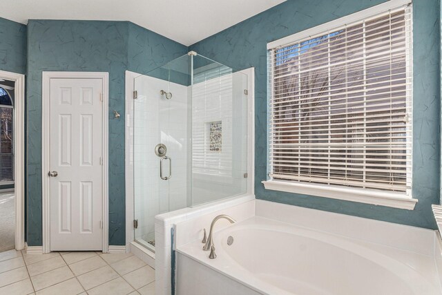 bathroom featuring a garden tub, a shower stall, and tile patterned flooring