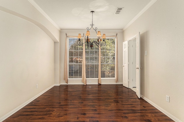 unfurnished dining area with an inviting chandelier, crown molding, wood finished floors, and visible vents