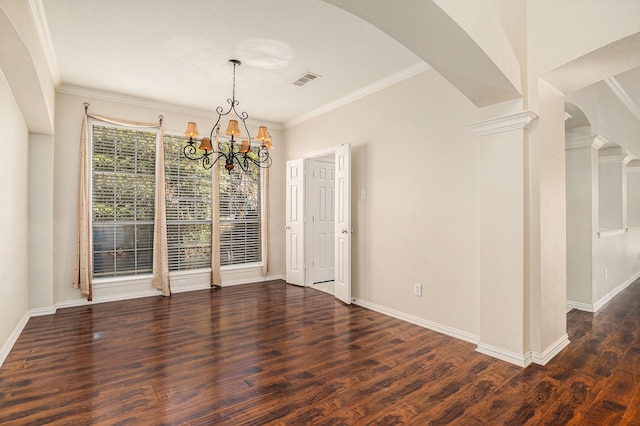 unfurnished dining area with ornate columns, ornamental molding, an inviting chandelier, and wood finished floors