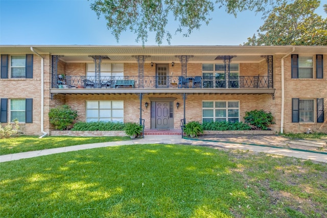 6131 Bandera Ave Unit A, Dallas, TX 75225 - view of front of home featuring a front yard, brick siding, and a balcony