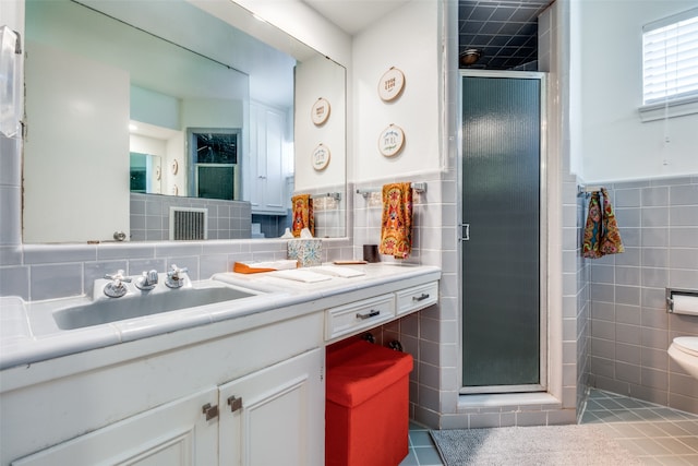 bathroom with walk in shower, tile patterned flooring, and tile walls