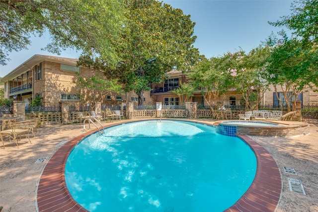 view of swimming pool featuring a community hot tub